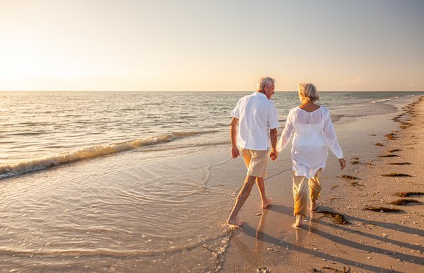 active-seniors-senior-couple-walking-beach-sunset