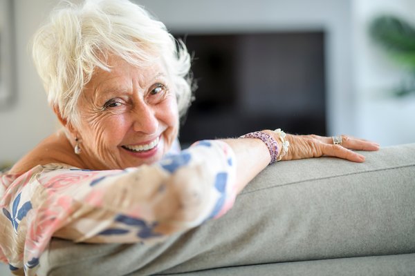 active-seniors-senior-woman-smiling-home-couch